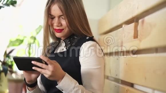 年轻漂亮的女人在咖啡店用手机检查收到的邮件视频的预览图