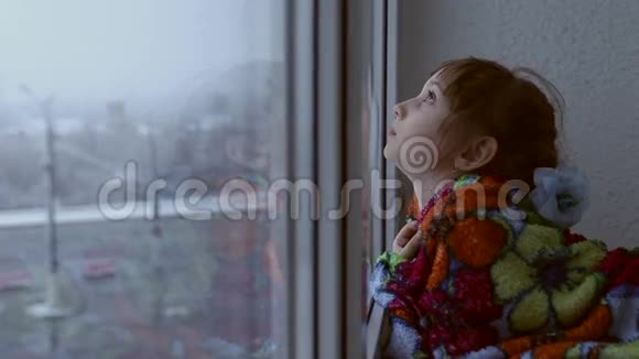 女孩望着窗外的雪视频的预览图