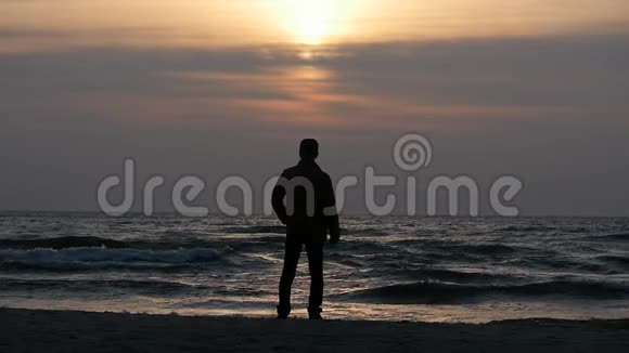 日落前人在傍晚海岸固定的静态轮廓视频的预览图