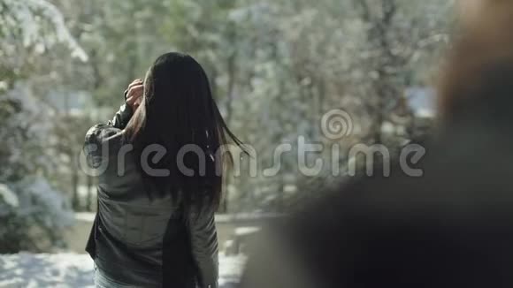 漂亮的拉丁女外套转向相机一幅长着棕色长发的女人在雪地里对着镜头微笑的肖像视频的预览图