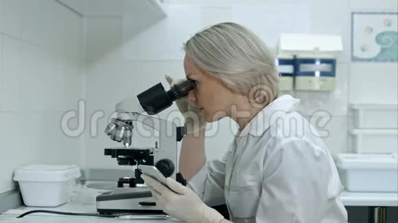化学实验室中使用显微镜和智能手机的科学家视频的预览图