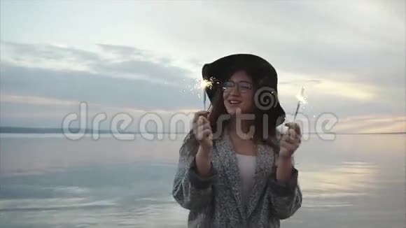 美丽快乐的女人在海滩日落时欢乐地跳舞视频的预览图