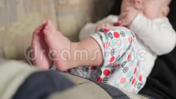 快乐的小男孩躺在爸爸腿上视频的预览图