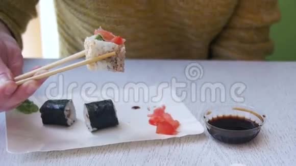 在日本餐馆吃寿司卷的女人慢动作视频的预览图