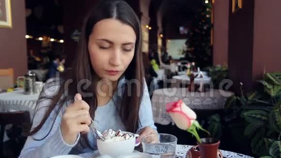 在咖啡馆里吃巧克力的女人视频的预览图
