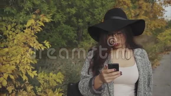 戴着黑色帽子和眼镜的年轻美女在户外自拍视频的预览图