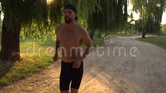 日落时分男跑者沿着公园的路跑视频的预览图