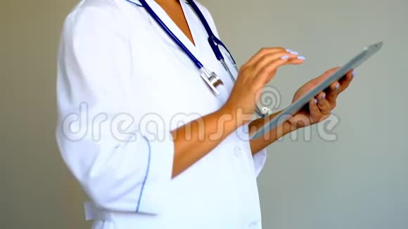 年轻女医生使用数字平板电脑医疗保健和医生服务视频的预览图
