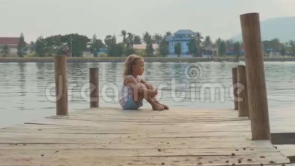 小女孩坐在木墩上慢动作享受大自然视频的预览图