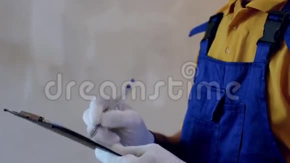 男修复员穿着蓝色的工作服做笔记女画家用白色画墙视频的预览图