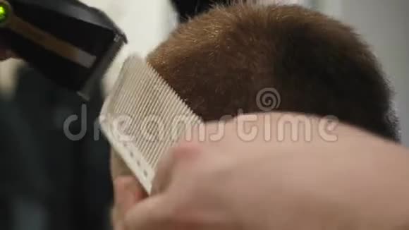 一个浓棕色头发的商人的特写他的头发在理发店里梳理和修剪剪辑Barbe视频的预览图