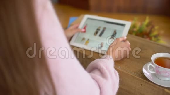 女士坐在她的办公桌与平板电脑看在线零售服装商店网站网站展示各种视频的预览图