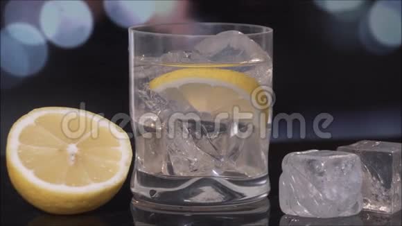 杜松子酒和黑背景的黄柠檬片视频的预览图