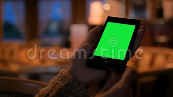 在咖啡馆里看着绿屏智能手机的女人视频的预览图