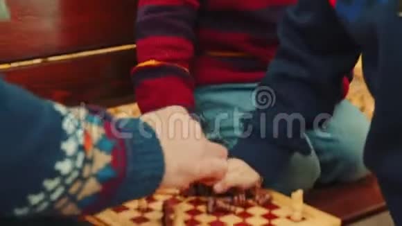 小男孩正在秋天公园的长凳上和爷爷下棋视频的预览图