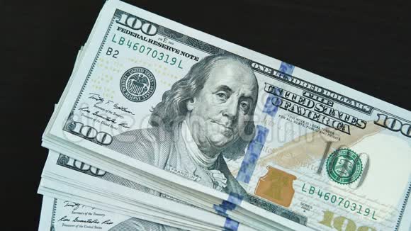 一美元的钞票落在黑桌上视频的预览图