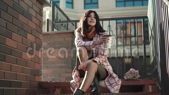 微笑的年轻女人在城里喝咖啡穿秋装的时髦女孩视频的预览图