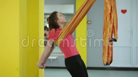 空中瑜伽的初学者用吊床做伸展胸部和背部的体式练习视频的预览图