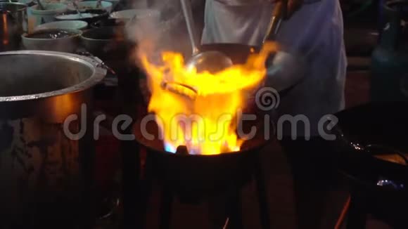 曼谷唐人街街边炒锅慢动作厨师晚上在马路上用蔬菜烧热油视频的预览图