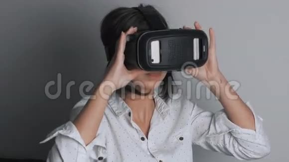 妇女使用头装显示器一个戴着虚拟现实面具的女人环顾四周视频的预览图