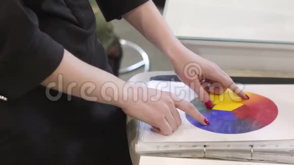 在创意办公室里女人手里拿着一个彩色车轮女性化妆师教授化妆技巧视频的预览图