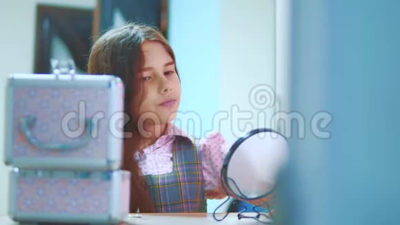 梳头的黑发小女孩照镜子小西班牙女孩在家里梳头视频的预览图