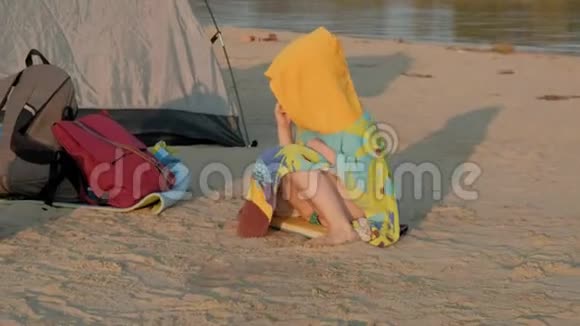 快乐的小女孩在海滩上吃饼干片暑假户外野餐视频的预览图
