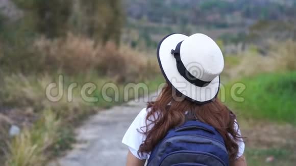 背着背包走在大自然小径上的女人视频的预览图