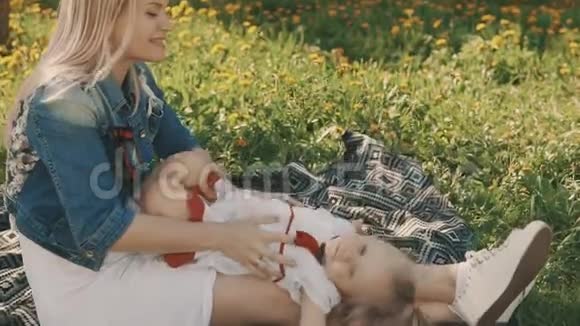 母女俩躺在户外草坪上母亲和童年的幸福视频的预览图