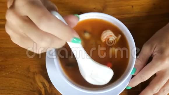 女人吃汤姆云古辣泰国汤与虾鱼和蘑菇印度尼西亚语巴厘岛亚洲视频的预览图