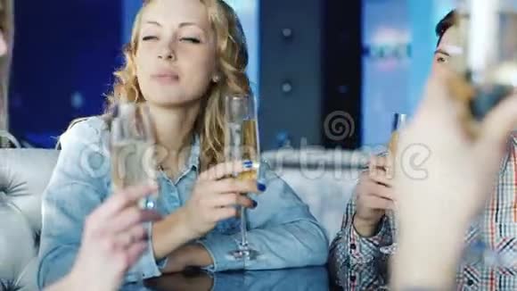 在咖啡馆里带着朋友的眼镜的年轻女人她向所有人表示祝贺视频的预览图