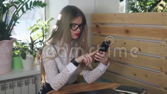 时尚的女商人在咖啡馆里用手机查信视频的预览图