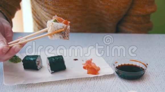 在日本餐馆吃寿司卷的女人慢动作视频的预览图