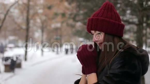美丽快乐女孩的肖像戴着时尚的针织冬帽和手套视频的预览图