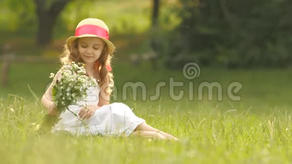 孩子手里拿着一束野花她闻着它们微笑着视频的预览图