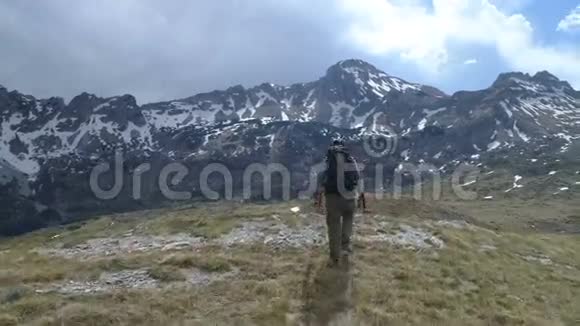 徒步旅行者走到山顶举起双臂做胜利的手势视频的预览图