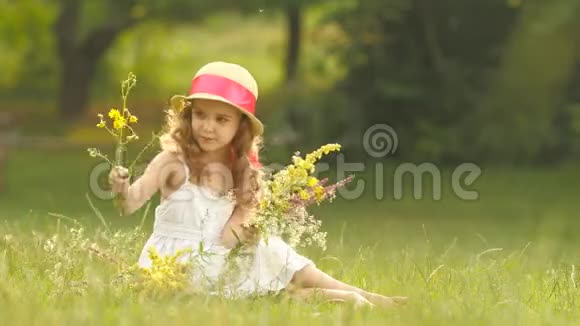 孩子手里拿着一束野花她闻着它们微笑着视频的预览图