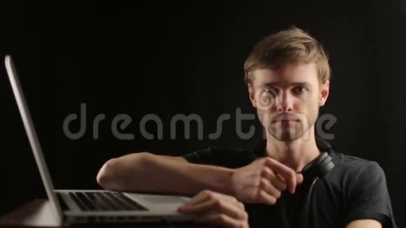 年轻的男性DJ能感受到笔记本电脑和舞蹈的节奏视频的预览图