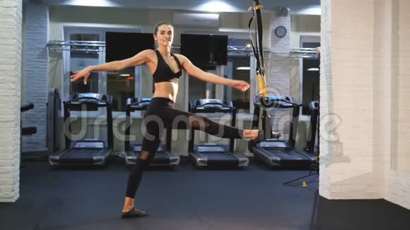 一位年轻漂亮的健身教练借助运动橡皮筋麻绳伸展腿部肌肉视频的预览图