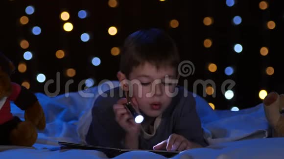 小男孩晚上在床上看书博克背景视频的预览图