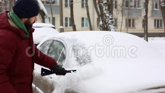 男人用刷子擦车上的雪在客厅里视频的预览图