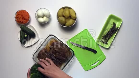 带有蔬菜和蛋黄酱的俄罗斯肉沙拉女人把原料切下来混合在一个容器里时间流逝视频的预览图