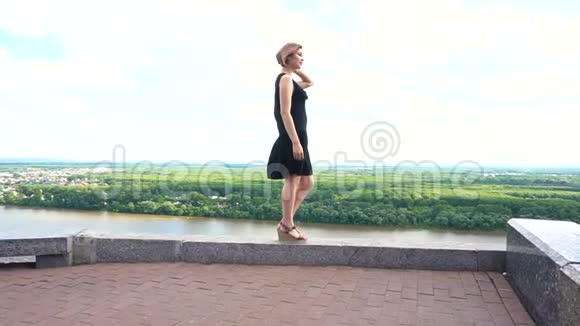 女孩独自站在城市的顶端望着远处的自然景观视频的预览图