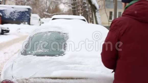 男人用刷子擦车上的雪在客厅里视频的预览图