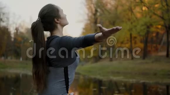 年轻女子在户外练习瑜伽女性冥想户外美丽的秋天自然视频的预览图