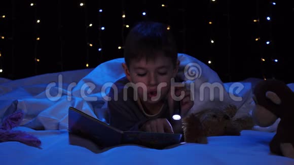 小男孩晚上在床上看书博克背景视频的预览图