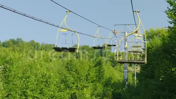 滑雪缆车的座位它们在森林覆盖的背景下向上移动假期视频的预览图