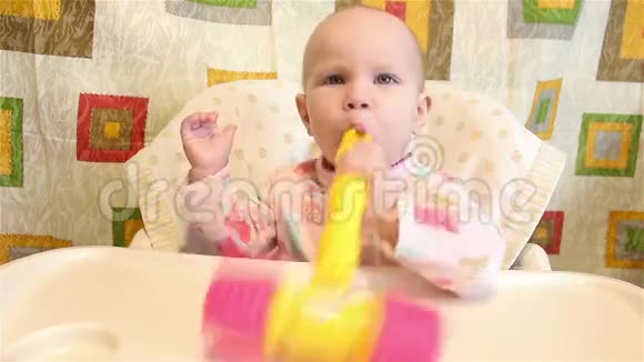 婴儿正坐着嘴里含着一个玩具视频的预览图