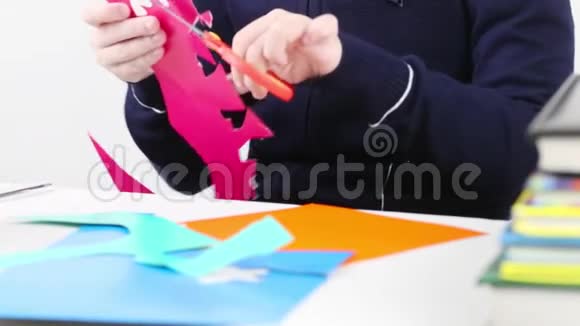 女孩的手从彩纸上剪出形状的工艺品视频的预览图