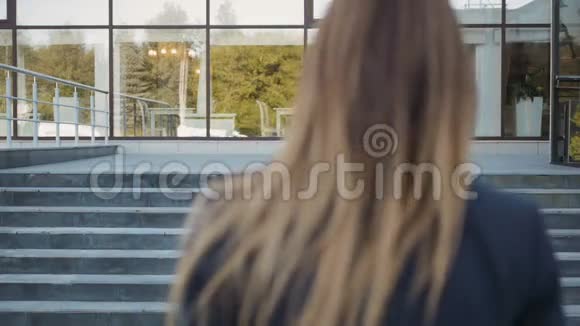 年轻商务女性走上楼梯打电话户外视频的预览图